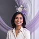 Headshot of a smiling South Asian woman in her late 30s, with soft lighting and a serene expression.